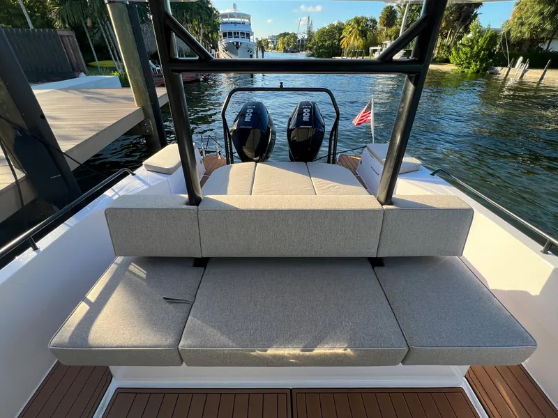 Slide: The Image of 2023 Axopar 37 Sun-Top boat with cushioned seating and twin outboard engines. - 28