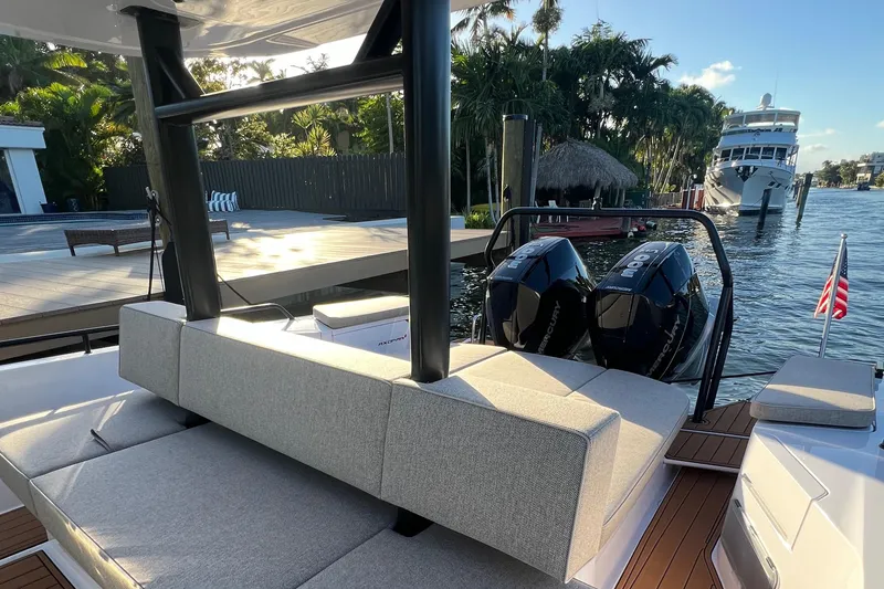 Slide: The Image of 2023 Axopar 37 Sun-Top boat with twin engines docked at a marina. - 30