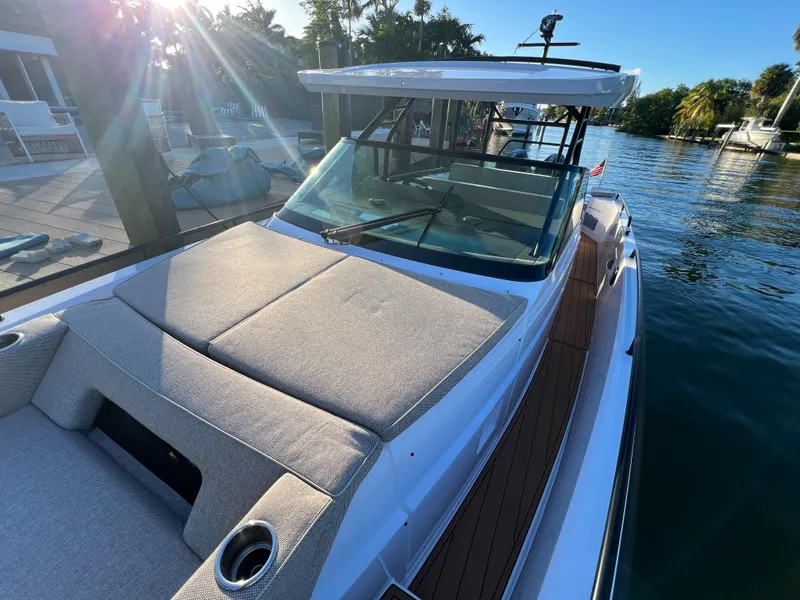 Slide: The Image of 2023 Axopar 37 Sun-Top boat docked by the water on a sunny day. - 39