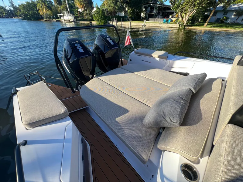 Slide: The Image of 2023 Axopar 37 Sun-Top boat with cushioned seating and twin outboard engines. - 43