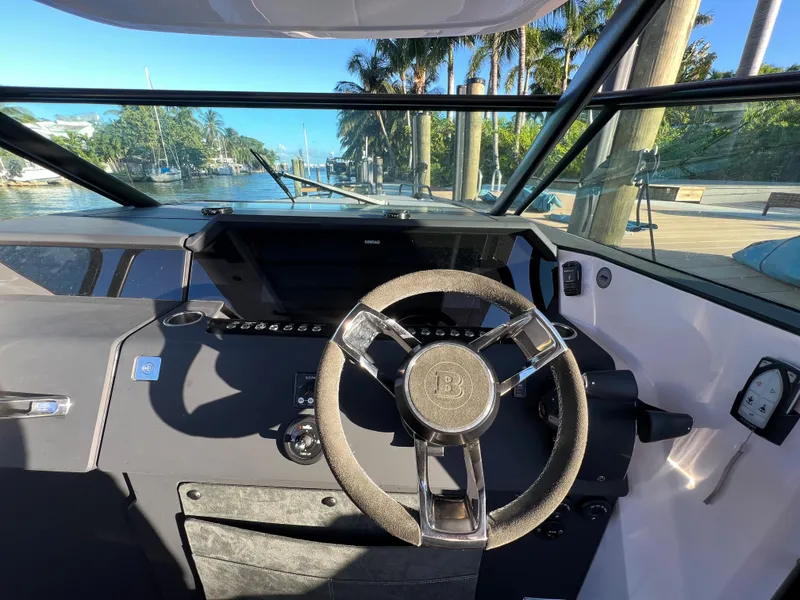 Slide: The Image of Helm of 2023 Axopar 37 Sun-Top boat with steering wheel and dashboard. - 49
