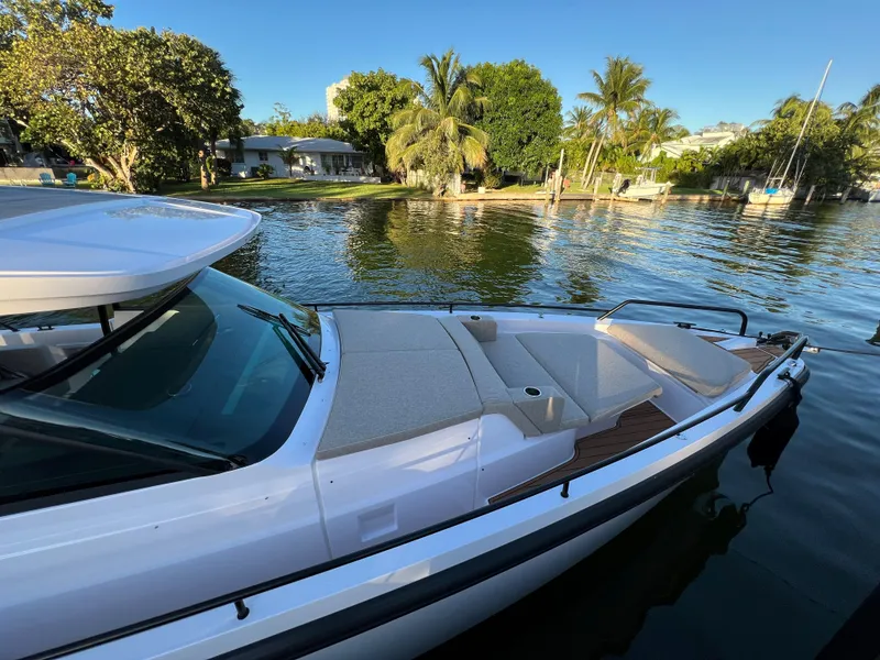 Slide: The Image of 2023 Axopar 37 Sun-Top boat docked near a tropical shoreline. - 8