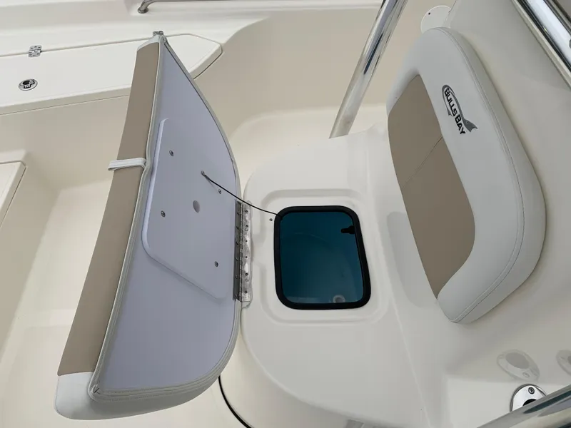 Slide: The Image of 2025 Bulls Bay 2400 boat interior with open storage compartment and cushioned seating. - 27