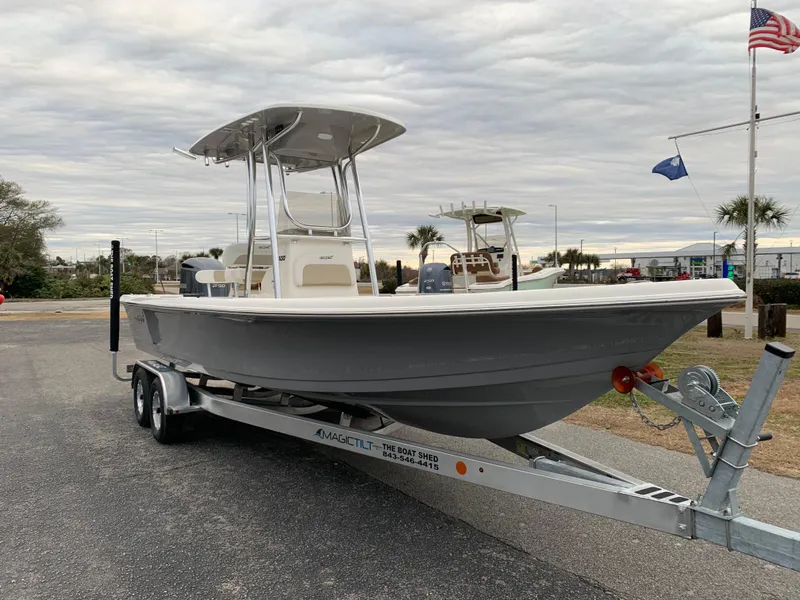 Slide: The Image of 2025 Bulls Bay 2400 boat on trailer, parked outdoors under cloudy sky. - 6