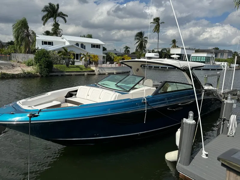 The Image of 2021 Sea Ray 400 SLX OB luxury boat docked in a scenic waterfront area. - 0