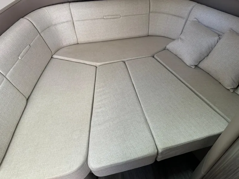 Slide: The Image of Interior seating area of 2021 Sea Ray 400 SLX OB boat with beige cushions. - 11