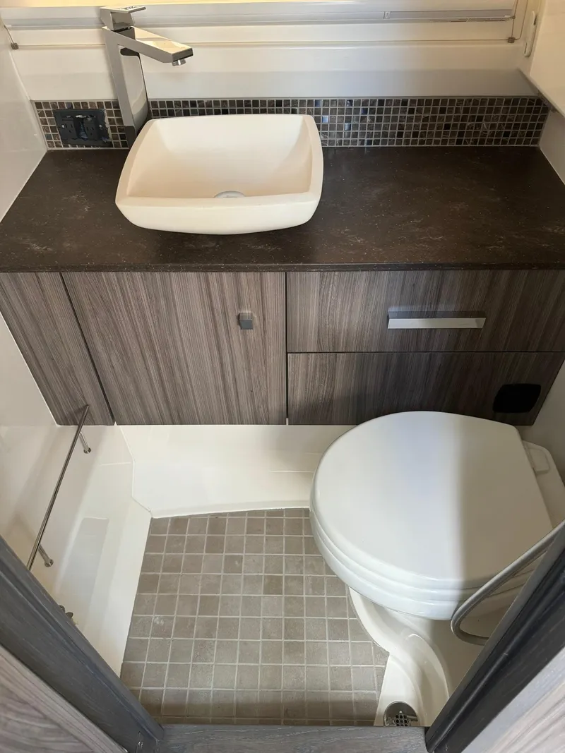 Slide: The Image of 2021 Sea Ray 400 SLX OB bathroom with modern sink and toilet - 13