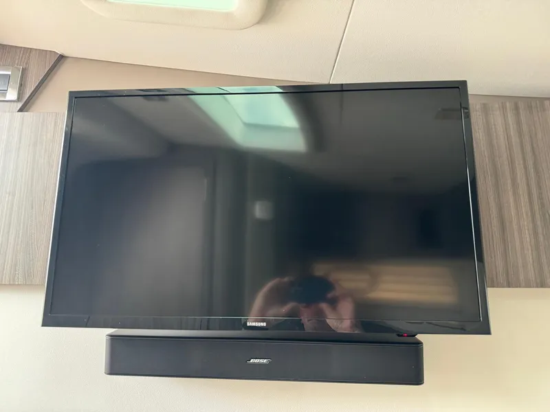 Slide: The Image of Samsung TV and Bose soundbar in 2021 Sea Ray 400 SLX OB boat interior. - 19