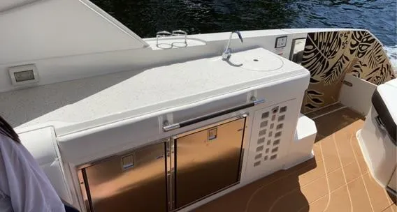 Slide: The Image of 2021 Sea Ray 400 SLX OB boat kitchen area with stainless steel appliances. - 20