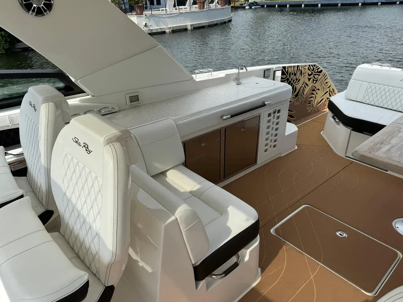 Slide: The Image of 2021 Sea Ray 400 SLX OB boat interior with white seating and kitchenette. - 5