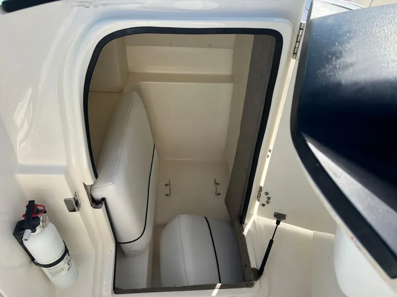 Slide: The Image of 2007 Sea Ray 250 SLX boat interior storage compartment with white cushioned seats. - 15