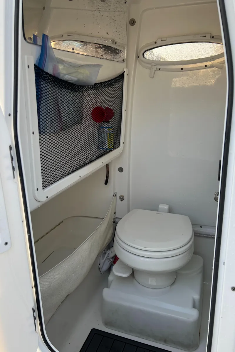 Slide: The Image of 2020 Sea Hunt Gamefish 25 boat interior bathroom with toilet and storage. - 36