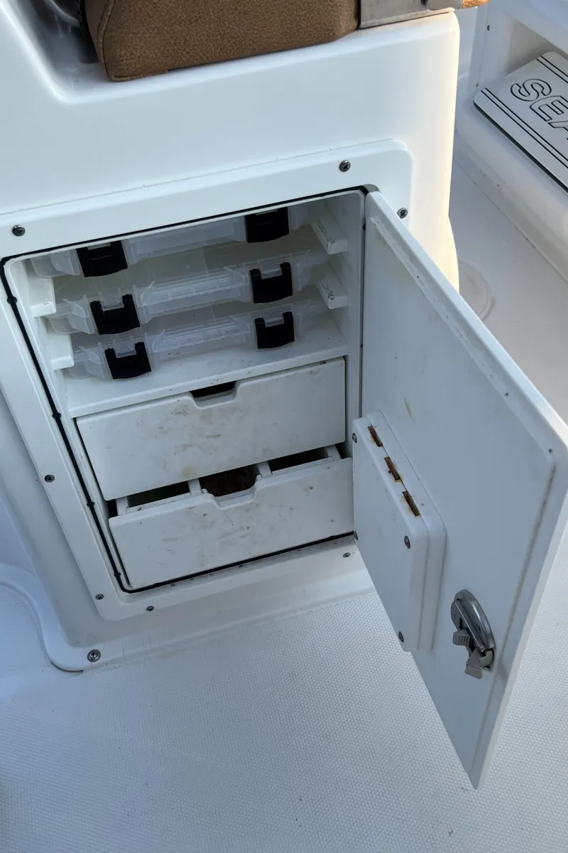 Slide: The Image of 2020 Sea Hunt Gamefish 25 tackle storage compartment with open door and organized trays. - 44