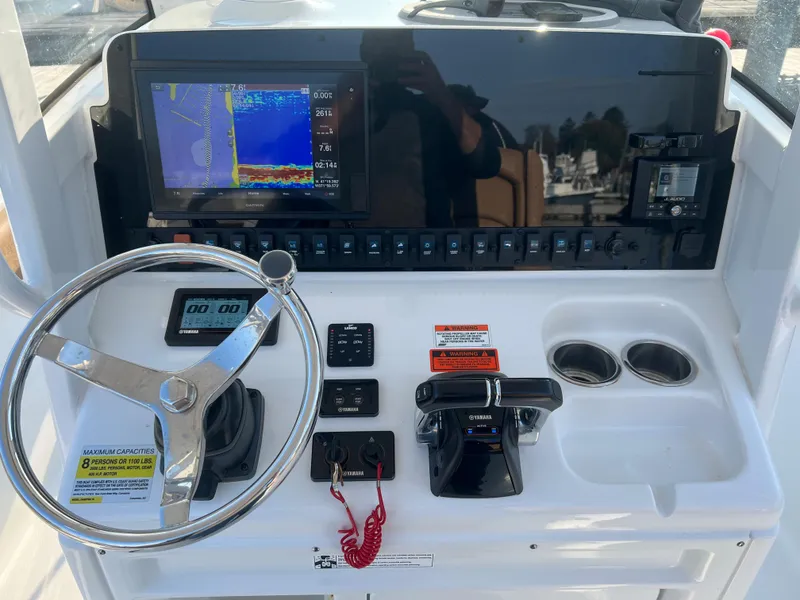 Slide: The Image of 2020 Sea Hunt Gamefish 25 helm with steering wheel, electronics, and controls. - 9