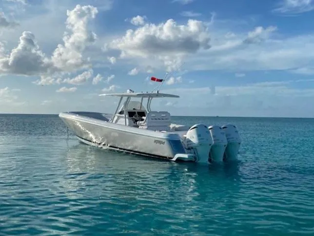 Slide: The Image of 2016 Intrepid 375 Center Console boat on clear blue water under a partly cloudy sky. - 1