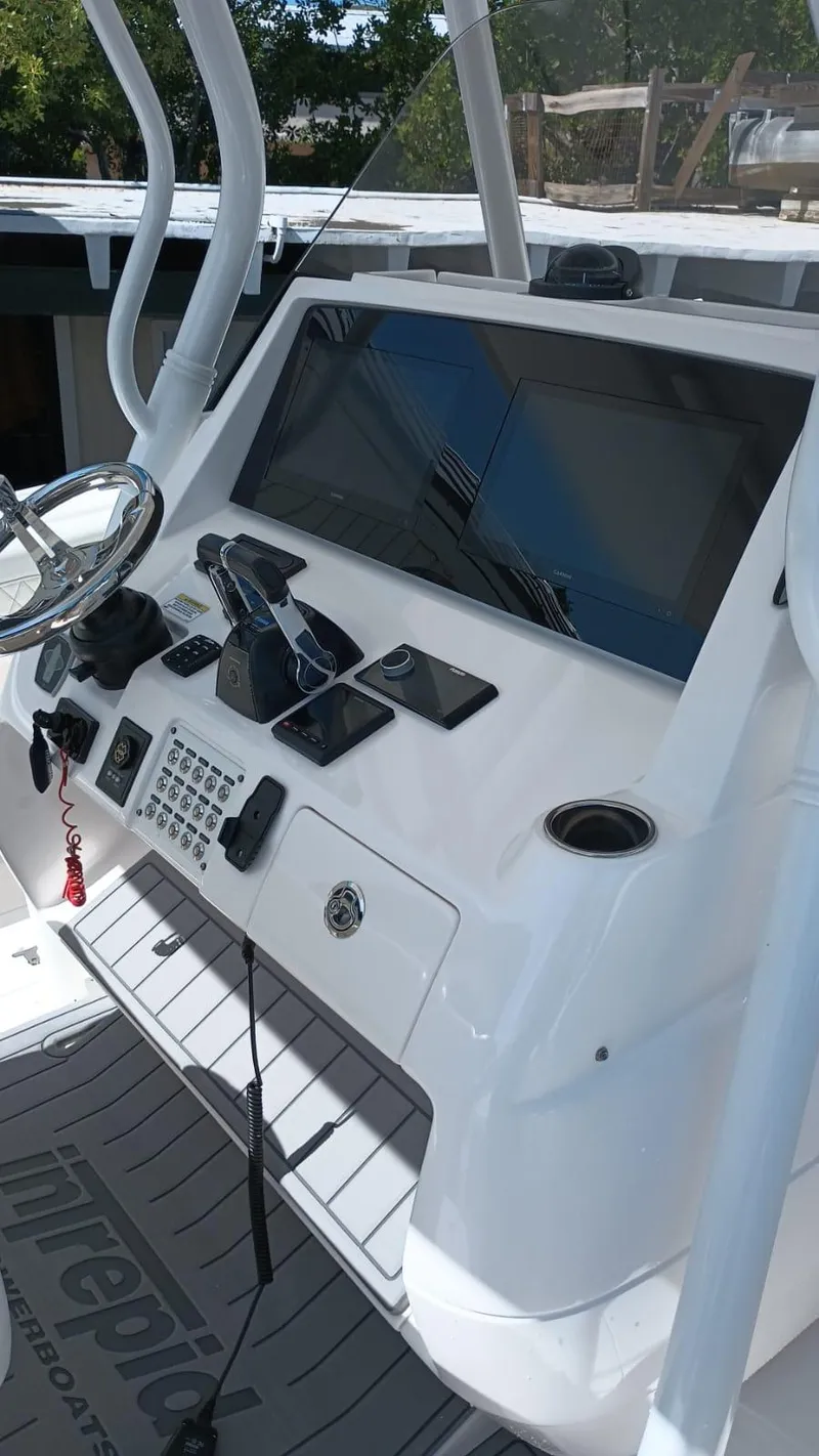 Slide: The Image of 2016 Intrepid 375 Center Console boat dashboard with steering wheel and electronic controls. - 12