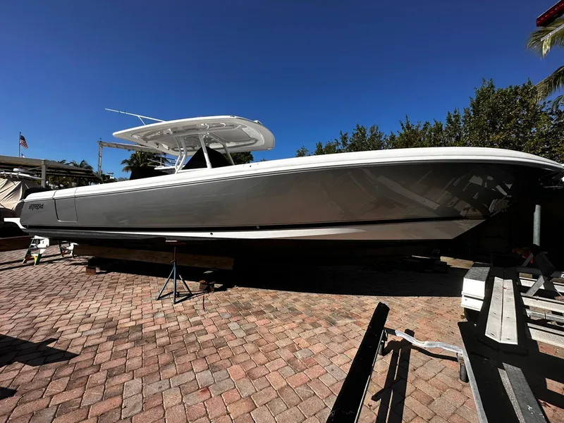 Slide: The Image of 2016 Intrepid 375 Center Console boat on a brick-paved surface under a clear blue sky. - 3