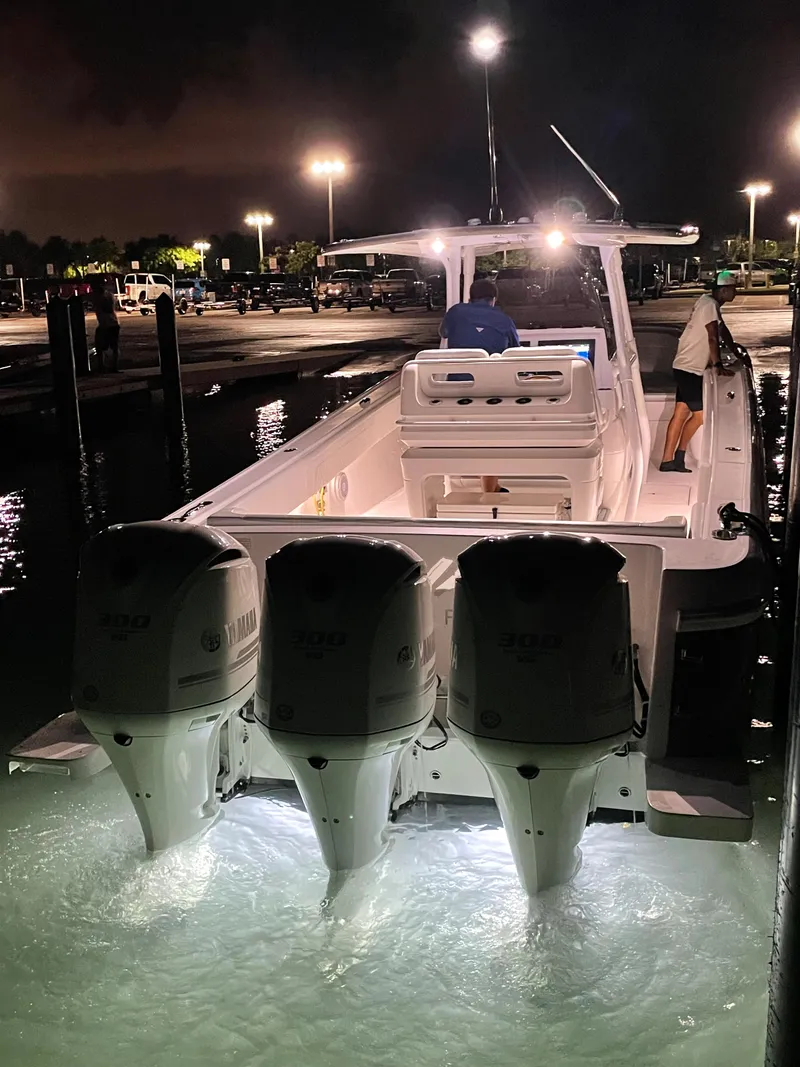 Slide: The Image of 2016 Intrepid 375 Center Console boat with triple Yamaha engines docked at night. - 7
