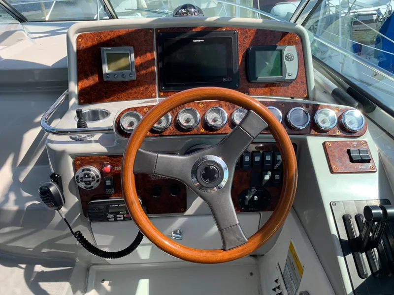 Slide: The Image of 2005 Formula 34 PC boat helm with wood-trimmed steering wheel and navigation instruments. - 18