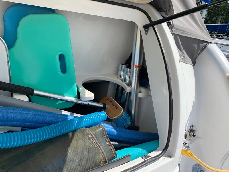 Slide: The Image of Storage compartment of a 2005 Formula 34 PC boat with cleaning supplies and pool noodles. - 4