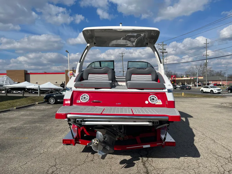 Slide: The Image of 2024 Regal LS9 boat, rear view, red and white, parked outdoors. - 13
