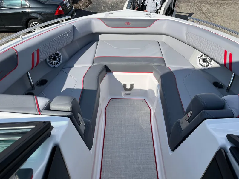 Slide: The Image of 2024 Regal LS9 boat interior with gray and red seating, cup holders, and speakers. - 4