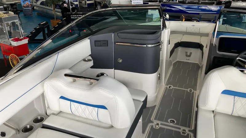 Slide: The Image of 2024 Regal LS6 boat interior with white and blue seating, modern dashboard, and spacious layout. - 5