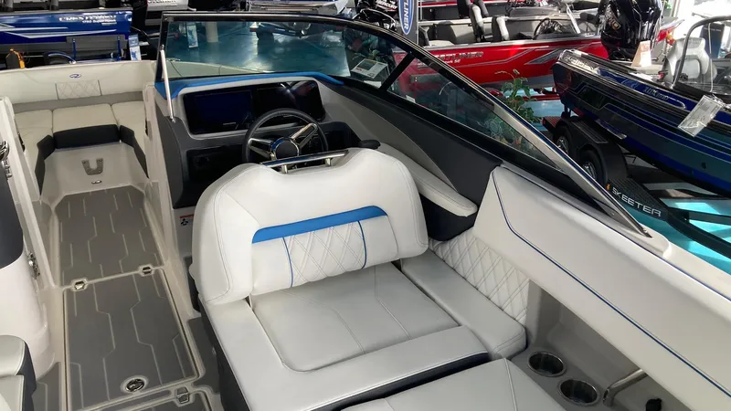 Slide: The Image of 2024 Regal LS6 boat interior with white and blue seating, steering wheel, and dashboard. - 6