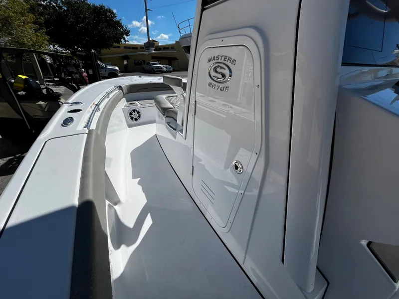 Slide: The Image of 2024 Sportsman Masters 267OE Bay Boat, sleek white deck and console. - 13