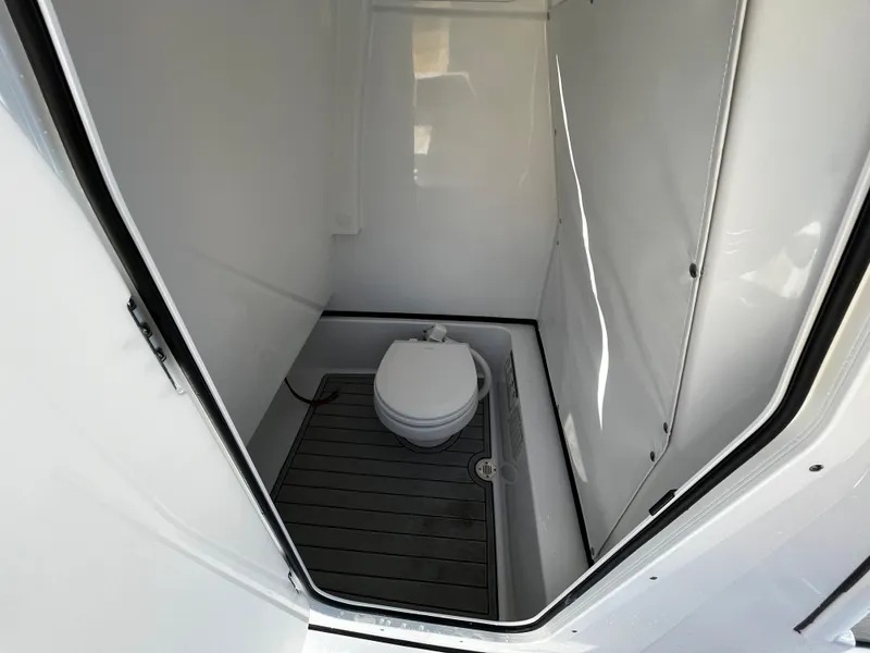 Slide: The Image of 2024 Sportsman Masters 267OE Bay Boat interior bathroom with toilet. - 14