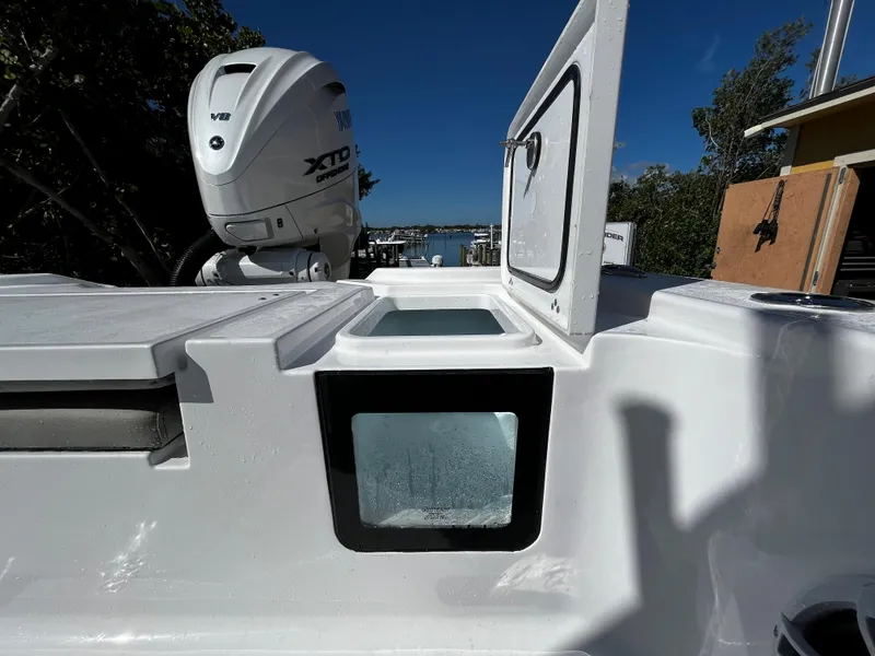 Slide: The Image of 2024 Sportsman Masters 267OE Bay Boat with open storage compartments and outboard motor. - 7