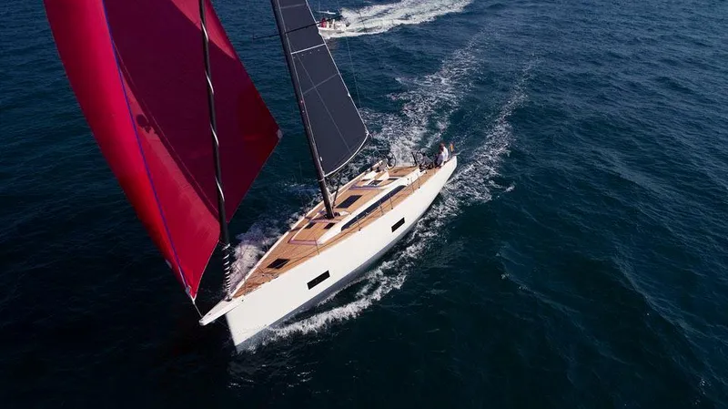 Slide: The Image of 2025 Solaris 44 yacht sailing with red and black sails on open sea. - 4