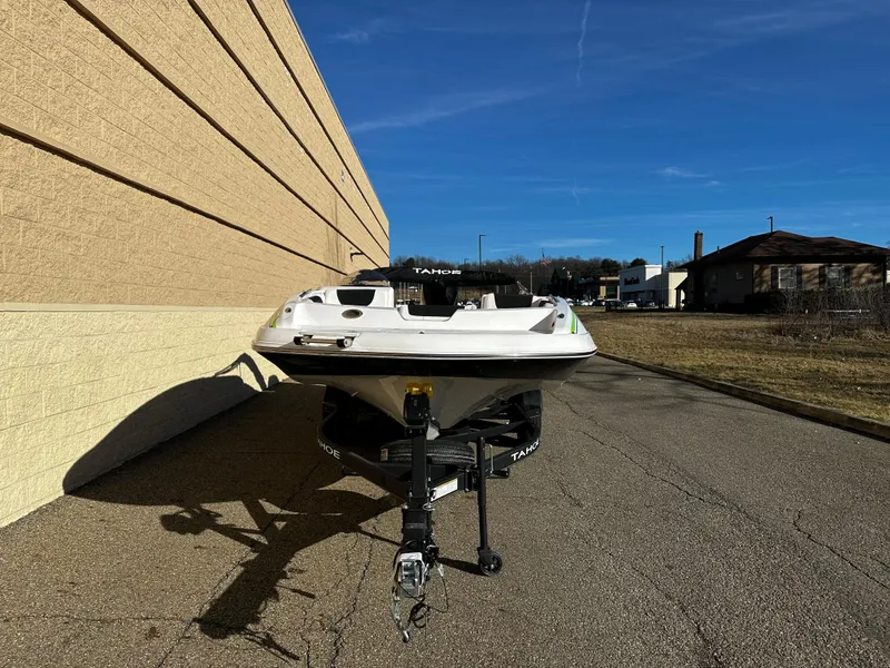 Slide: The Image of 2024 Tahoe 2150 boat on a trailer, parked outdoors near a building. - 5
