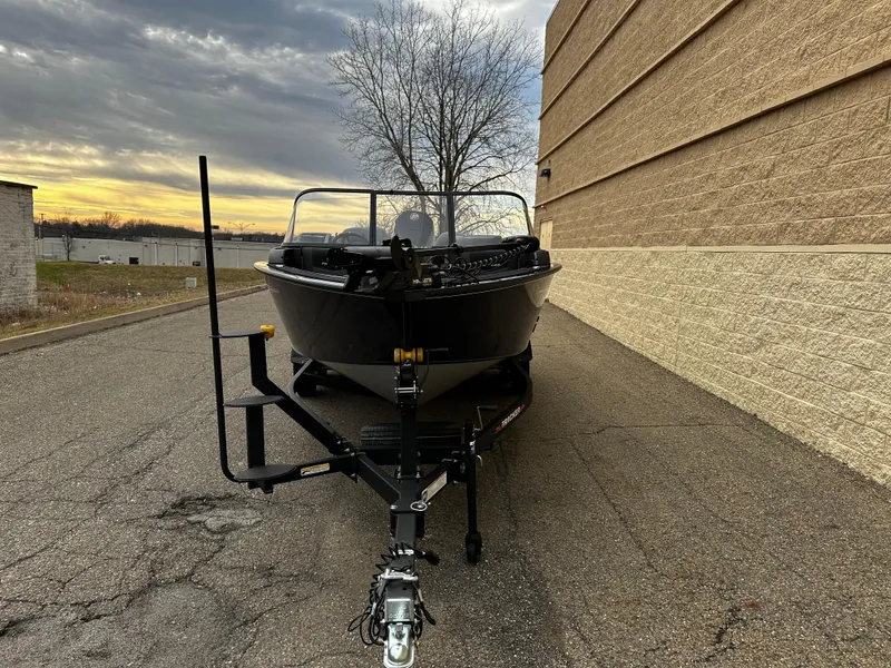 Slide: The Image of 2024 Tracker Targa V-19 WT boat on trailer, parked beside a building at sunset. - 3