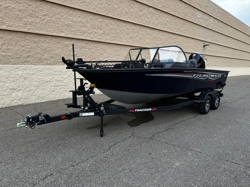 Slide: The Image of 2024 Tracker Targa V-19 WT boat on a trailer, parked beside a beige wall. - 9
