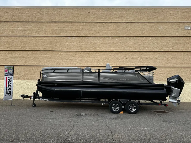 Slide: The Image of 2024 Regency 230 LE3 Sport pontoon boat on trailer, displayed outdoors. - 10