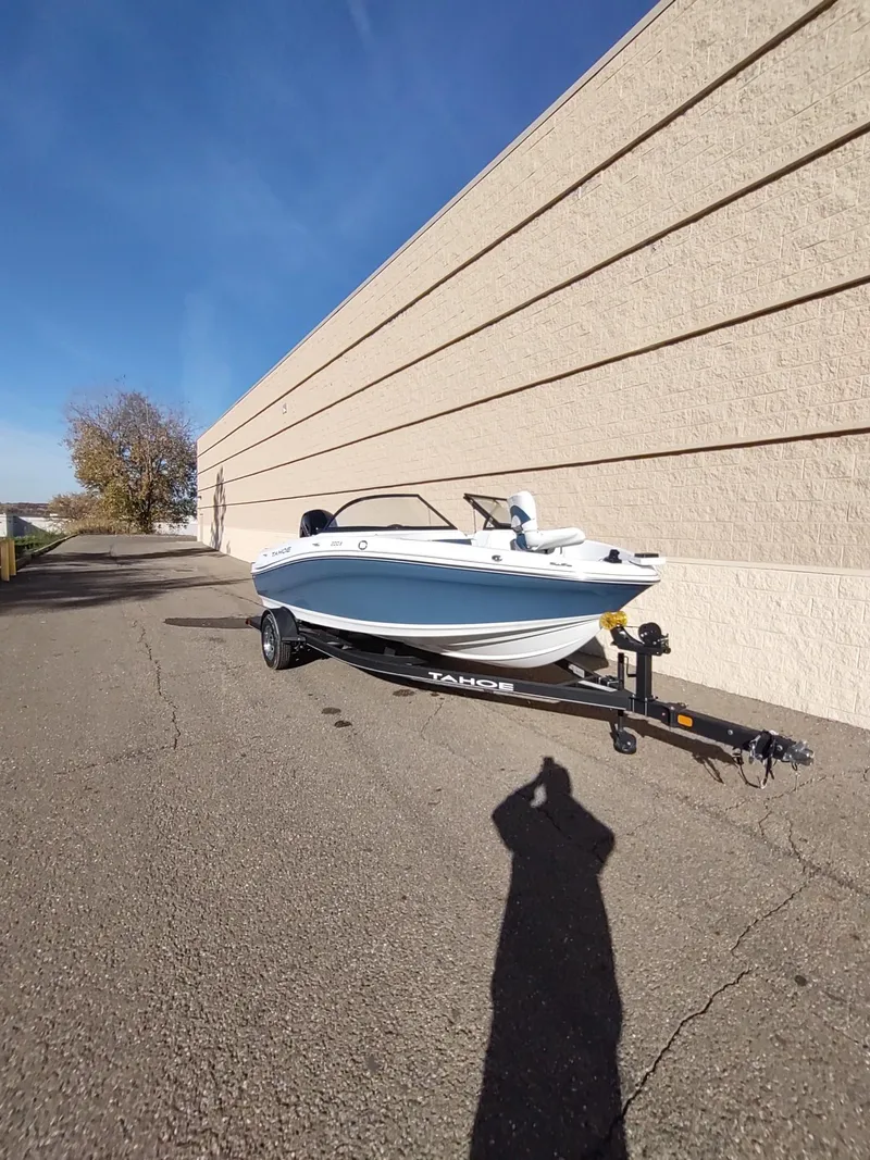 Slide: The Image of 2024 Tahoe 200 S boat on trailer beside a beige wall under clear blue sky. - 3