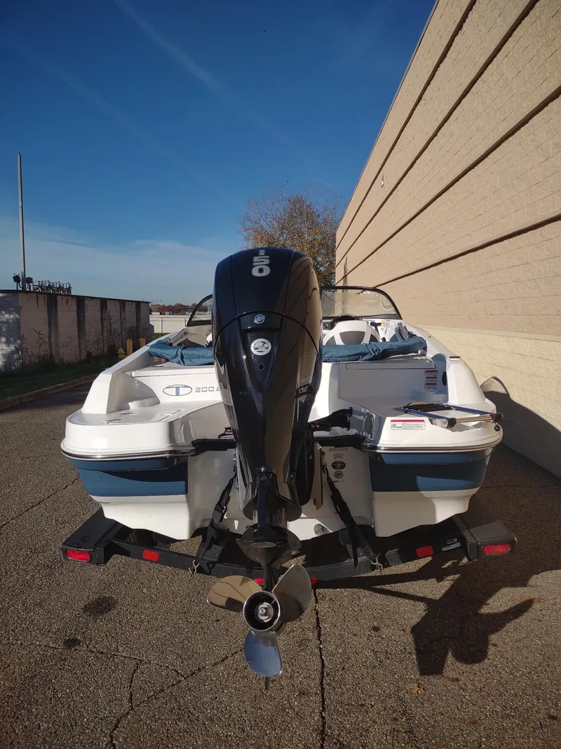 Slide: The Image of 2024 Tahoe 200 S boat with outboard motor on a trailer, parked outdoors. - 5