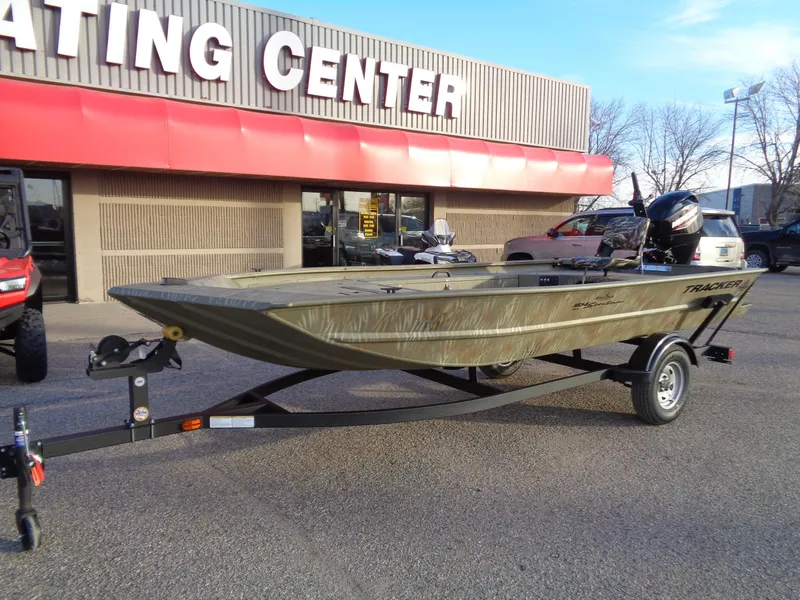 Slide: The Image of 2024 Tracker Grizzly 1654 T Sportsman boat on trailer outside dealership. - 2