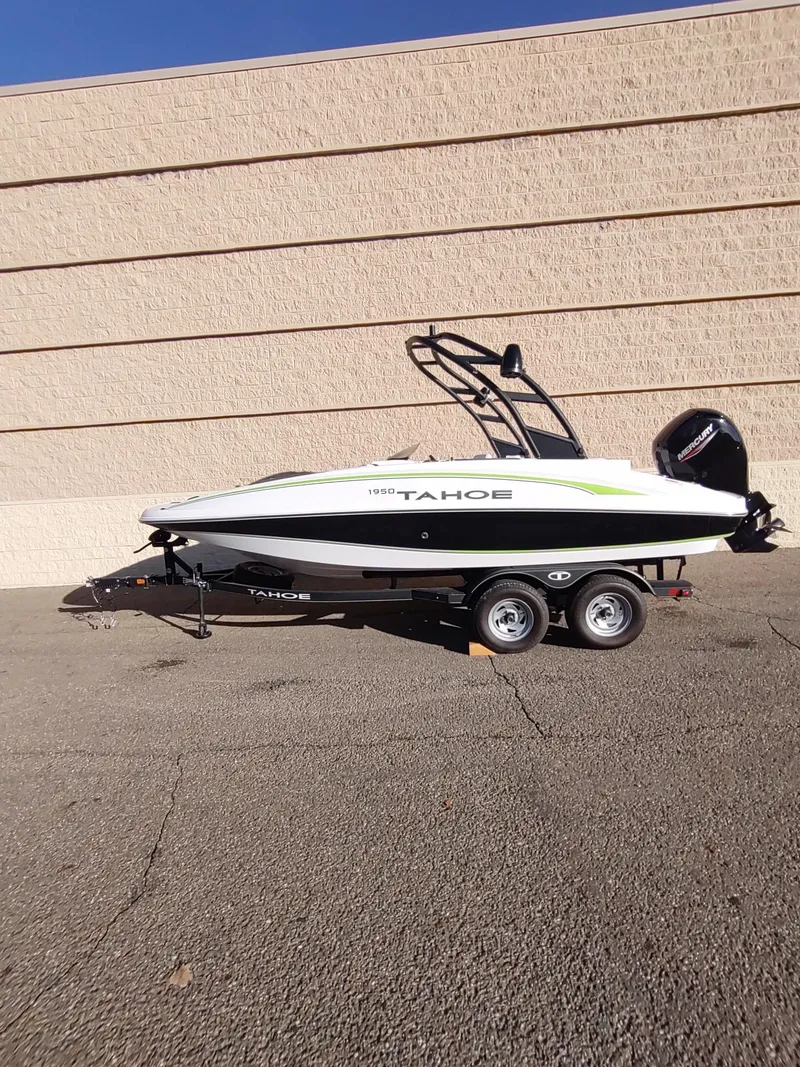 Slide: The Image of 2024 Tahoe 1950 boat on trailer, parked against a beige wall. - 1