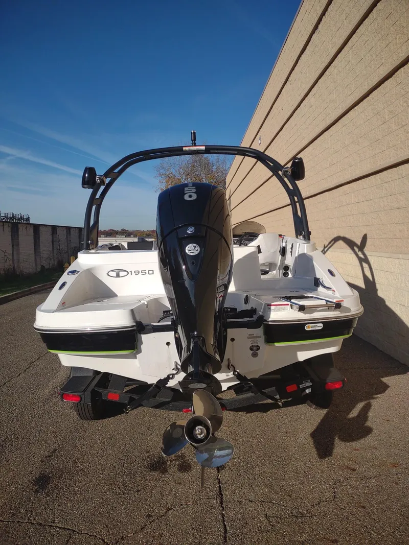Slide: The Image of 2024 Tahoe 1950 boat, rear view, parked outdoors, showcasing motor and sleek design. - 4