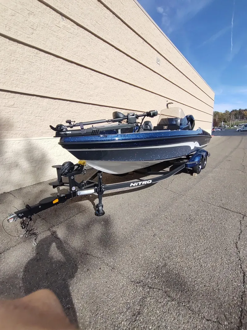 Slide: The Image of 2024 Nitro ZV21 Pro fishing boat on trailer, parked outdoors. - 2