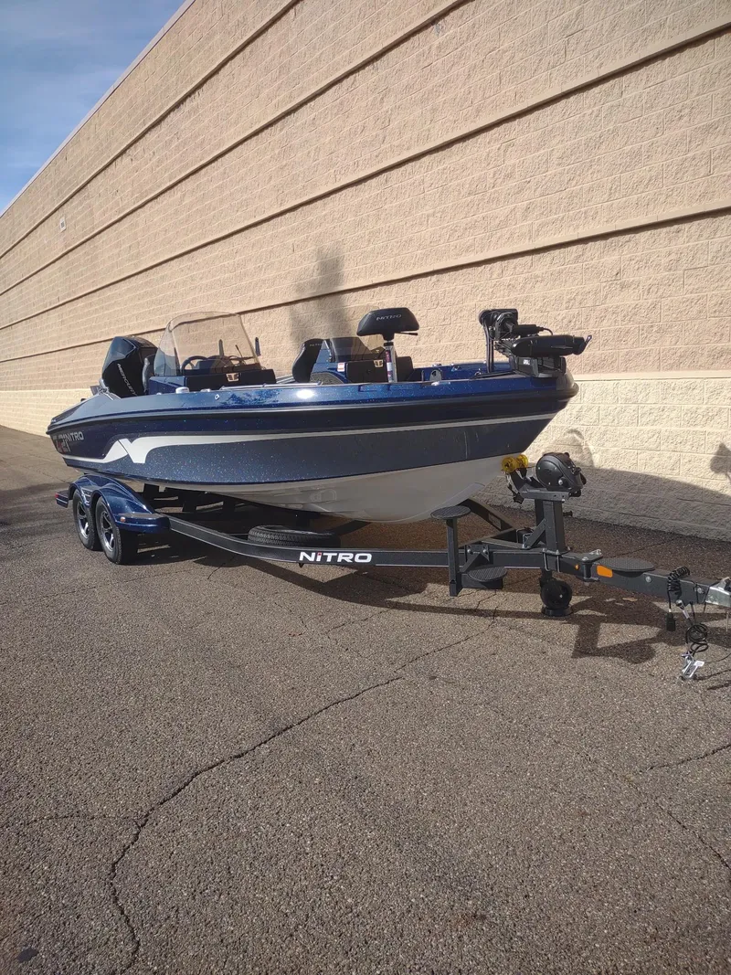 Slide: The Image of 2024 Nitro ZV21 Pro boat on trailer, parked beside a beige wall. - 6