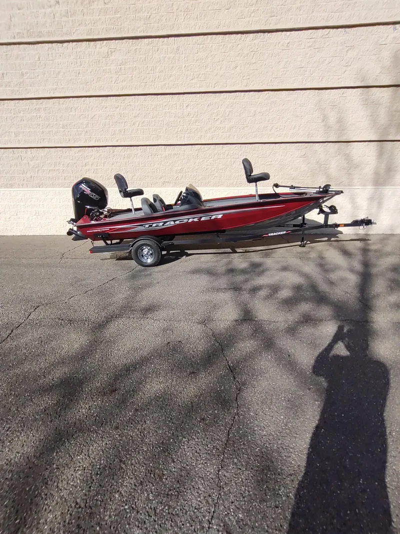 Slide: The Image of 2024 Tracker Pro Team 190 TX boat parked on pavement, side view. - 4