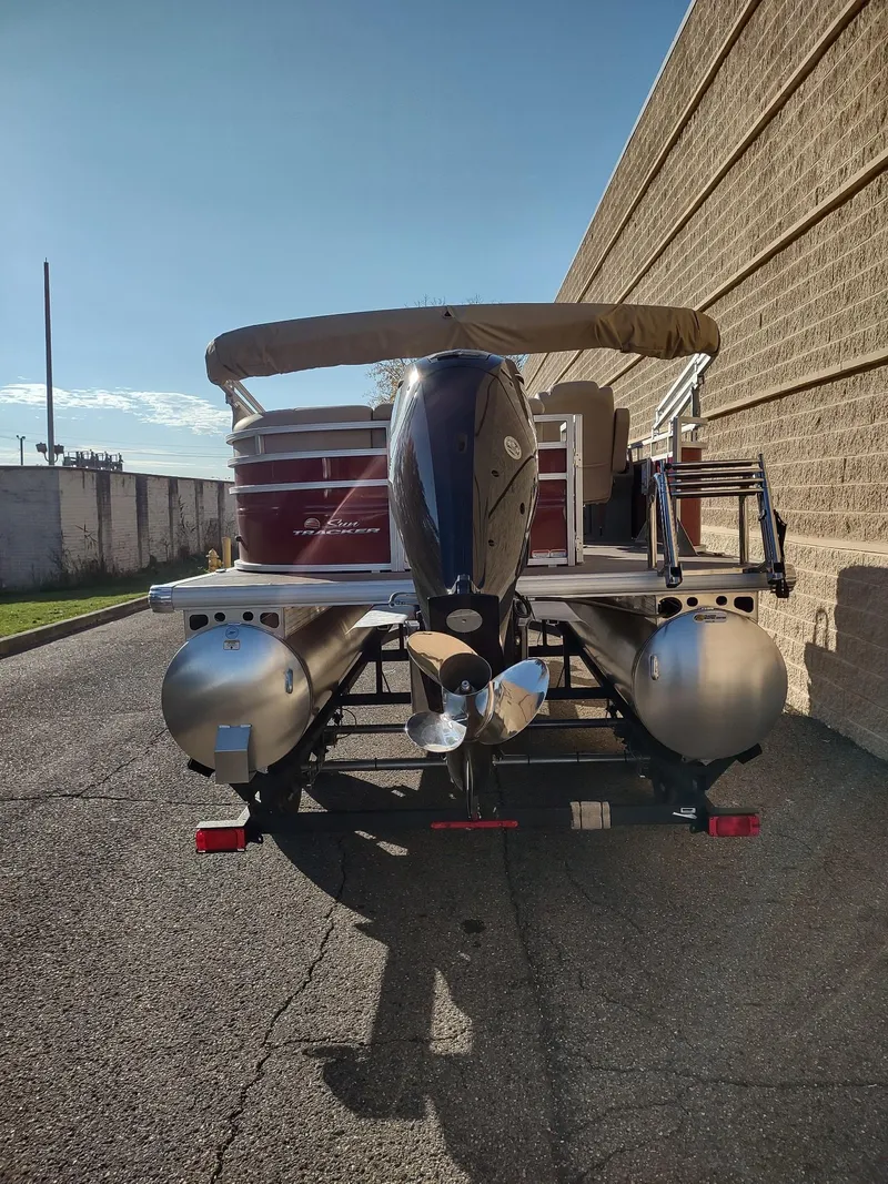 Slide: The Image of 2024 Sun Tracker Party Barge 20 DLX pontoon boat, rear view, parked outdoors. - 6