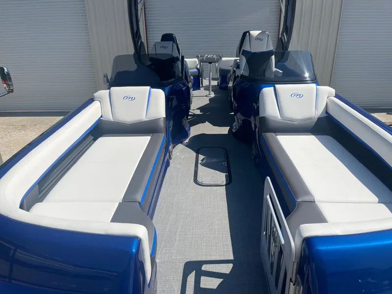 Slide: The Image of 2024 Manitou 25 XT SHP DE pontoon boat with blue and white seating. - 13