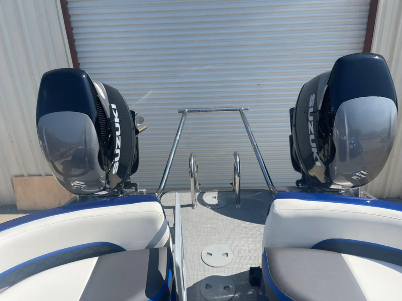 Slide: The Image of 2024 Manitou 25 XT SHP DE boat with dual Suzuki outboard motors. - 3