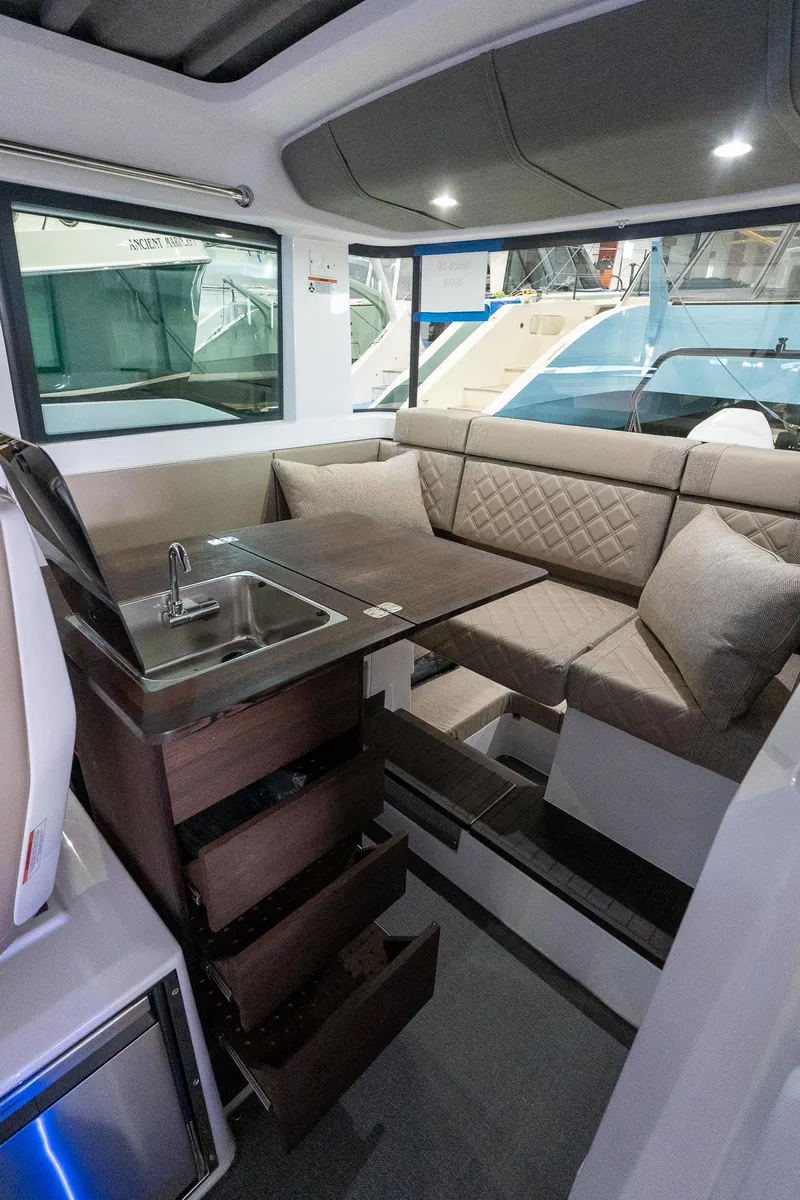 Slide: The Image of 2024 Axopar 37 Cross Cabin XC interior with seating, table, and sink. - 27