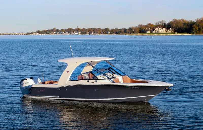 The Image of 2018 Scout 275 Dorado boat on calm water with scenic shoreline background. - 1
