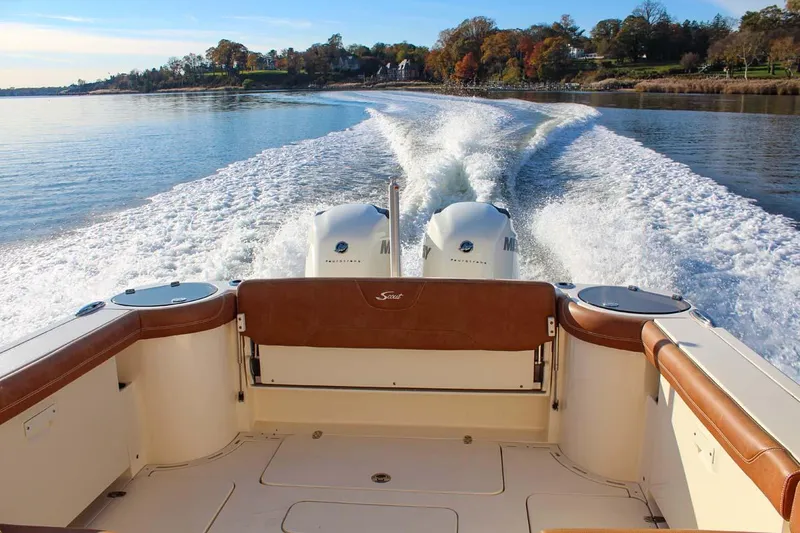 Slide: The Image of 2018 Scout 275 Dorado boat cruising on a calm lake with twin engines. - 14